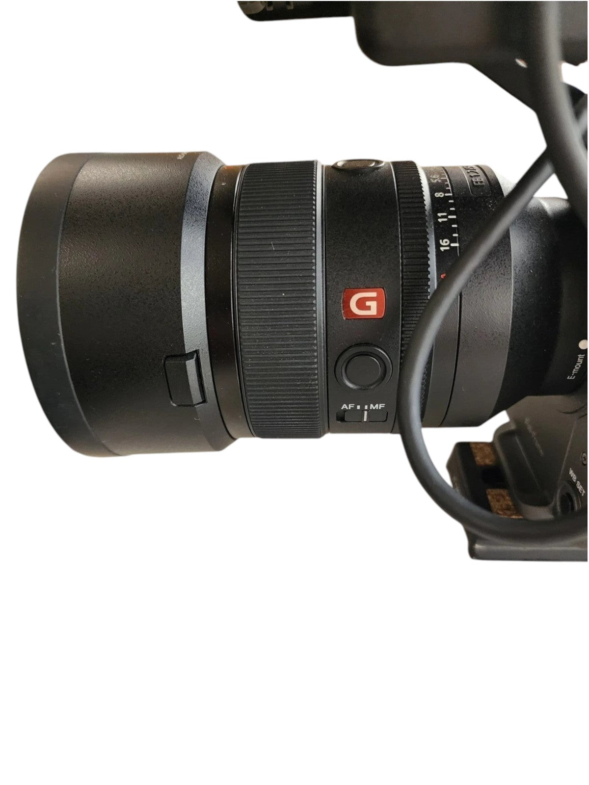 Cymer Sony FX6 cinema camera lens with G Master branding and manual focus switch on a marble surface.